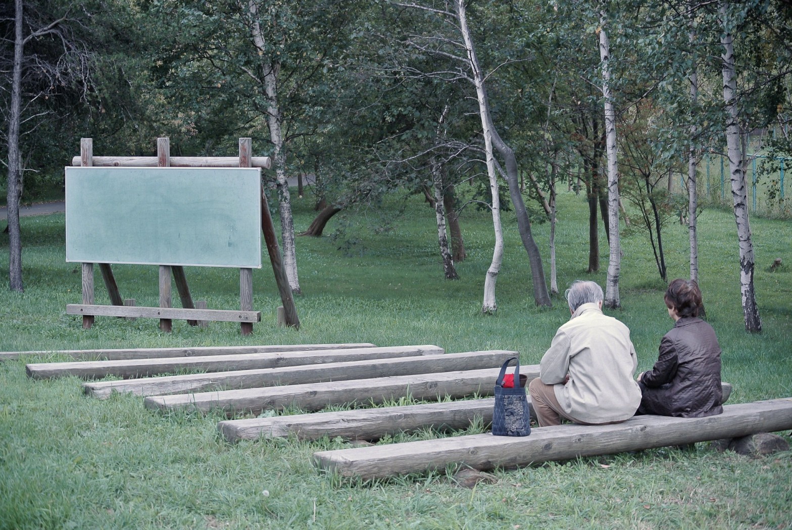 Image of two people sitting at an outdoor classroom